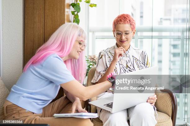 lesbian couple working with laptop at home - 非二元性別 個照片及圖片檔