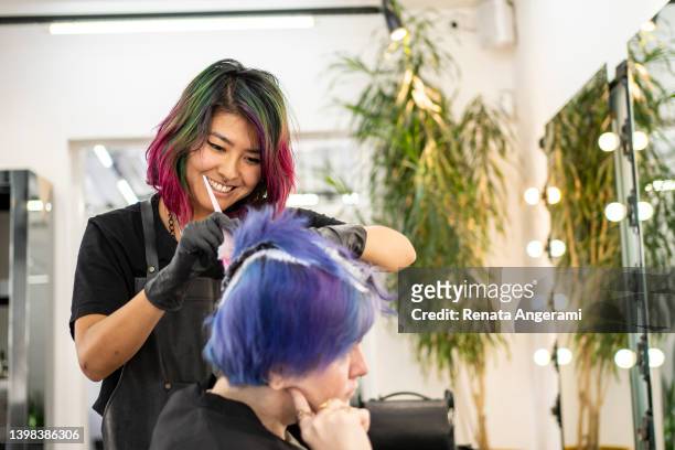 hairdresser dyeing client's hair at hair salon - hair coloring stock pictures, royalty-free photos & images
