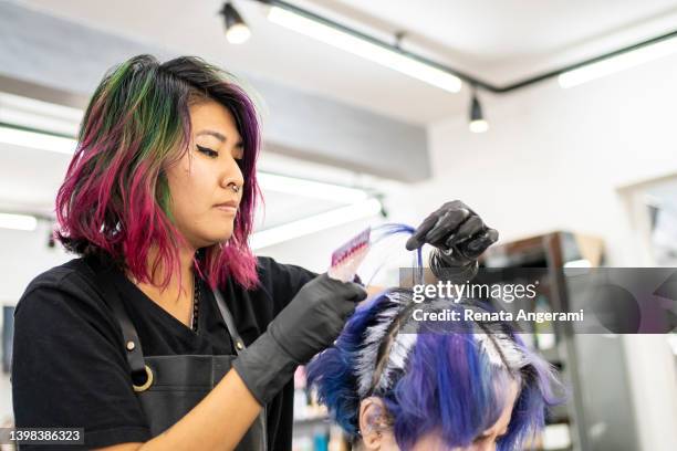 hairdresser dyeing client's hair at hair salon - hair coloring stock pictures, royalty-free photos & images