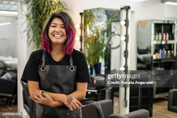 portrait de coiffeur aux cheveux teints au salon de coiffure - women barbers photos et images de collection
