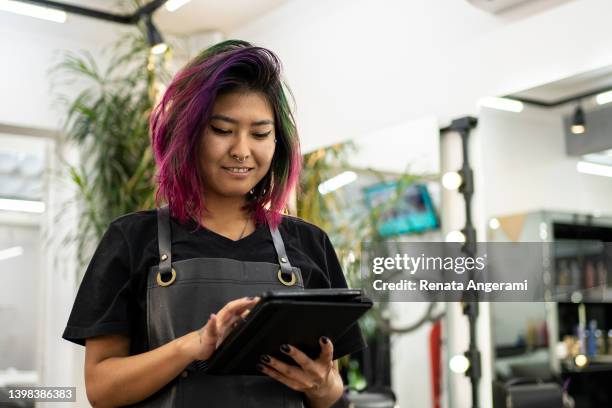portrait of hairdresser with dye hair using digital tablet at hair salon - hairdresser stock pictures, royalty-free photos & images