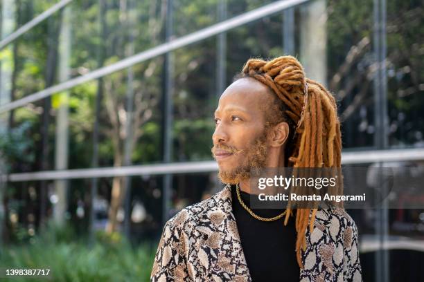 portrait of black man with dreadlocked hair with smart phone outside the office building - dreadlocks stock pictures, royalty-free photos & images