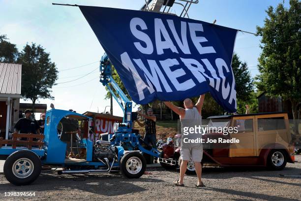 Tim Herrington helps put up a Save America sign before the arrival of Republican Gubernatorial candidate David Perdue and Rep. Marjorie Taylor Greene...