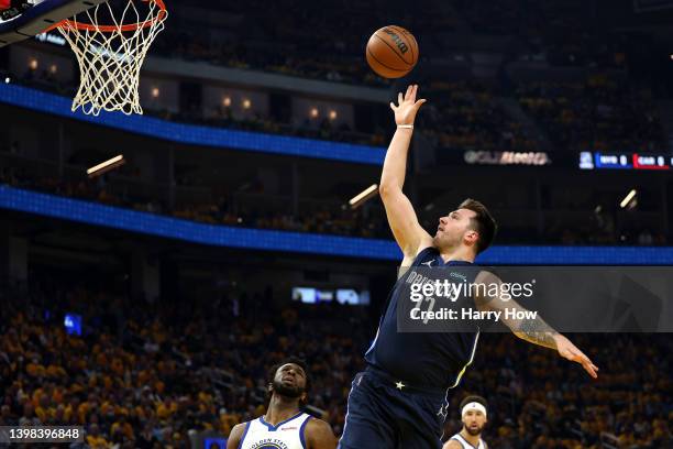 Luka Doncic of the Dallas Mavericks scores and gets fouled by Andrew Wiggins of the Golden State Warriors during the first quarter in Game Two of the...