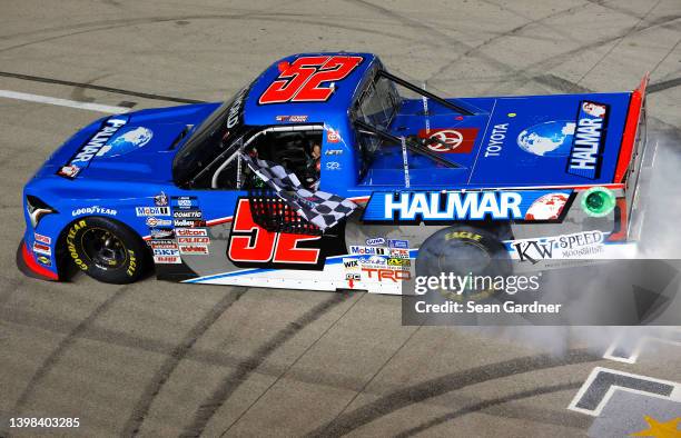 Stewart Friesen, driver of the Halmar International Toyota, celebrates with a burnout and checkered flag after winning the NASCAR Camping World Truck...