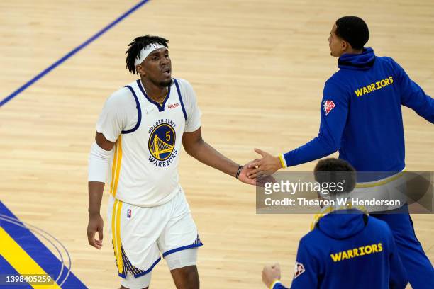 Kevon Looney of the Golden State Warriors celebrates a dunk with teammates at the end of the third quarter against the Dallas Mavericks in Game Two...