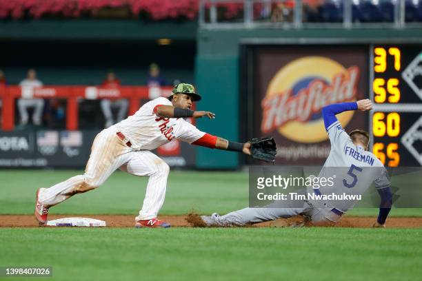 Jean Segura of the Philadelphia Phillies reaches for the ball as Freddie Freeman of the Los Angeles Dodgers slides to second base during the ninth...