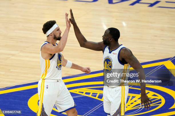 Klay Thompson and Draymond Green of the Golden State Warriors celebrate after a play during the fourth quarter against the Dallas Mavericks in Game...