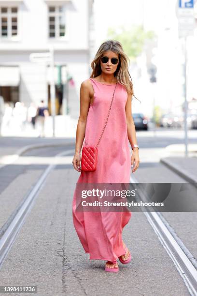 Influencer Gitta Banko wearing a light pink sleeveless maxi dress with slits by Liviana Conti, light pink flip flops by Gucci and sunglasses by...