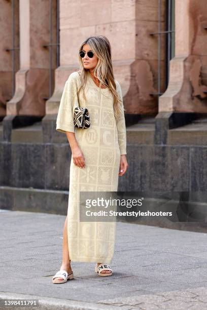 Influencer Gitta Banko wearing a long pale yellow crochet maxi dress by Nanushka, white sandals by Chanel, a black and beige bag by Saint Laurent and...
