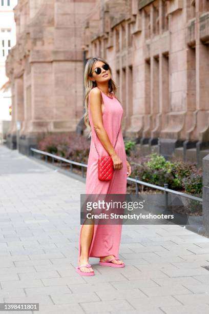 Influencer Gitta Banko wearing a light pink sleeveless maxi dress with slits by Liviana Conti, light pink flip flops by Gucci and sunglasses by...
