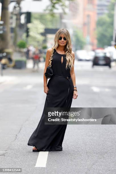 Influencer Gitta Banko wearing a black maxi dress with open back by Nicowa, a black bag with chunky gold chain by Bottega Veneta, sunglasses by...