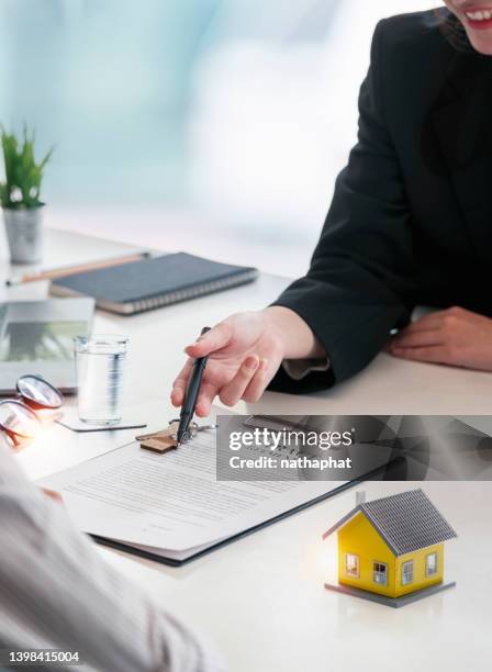 Real estate agent holding House model and customer discussing for contract to buy house, insurance or loan real estate concept and background.