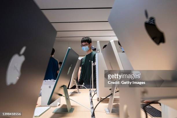 Customers interact with Apple products at the new Apple retail store at Wuhan International Plaza on May 21, 2022 in Wuhan, Hubei Province, China....