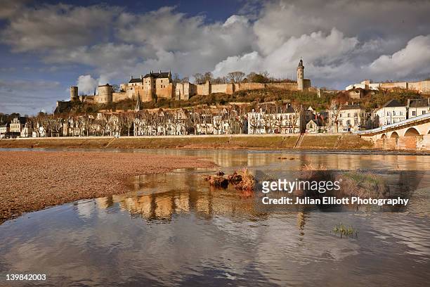 the imposing chateau of chinon in france sitting above the town of the same name. subtle reflections can be seen in the river vienne. the town and chateau are a part of the loire valley. - indre et loire stock-fotos und bilder