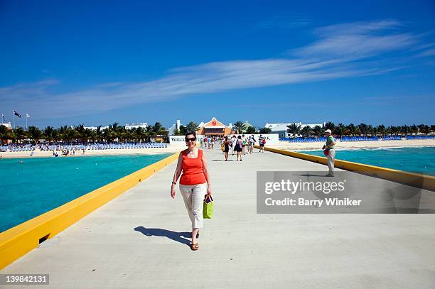 middle-aged woman on pier near new cruise ship complex, modern shopping center in grand turk, turks and caicos, caribbean sea - turks and caicos stock pictures, royalty-free photos & images