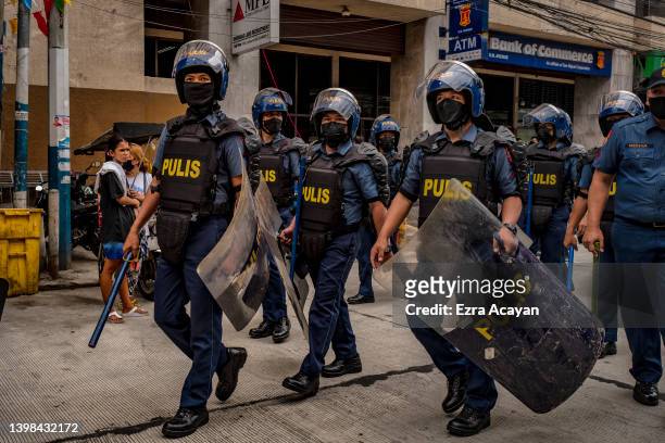 Riot police officers move to position outside the U.S. Embassy after dispersing and arresting Filipinos protesting against U.S. President Joe Biden's...