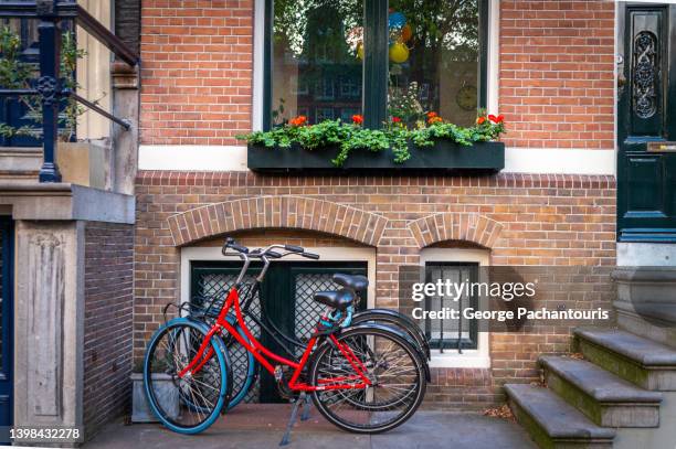 bicycles parked in front of an old house in amsterdam, holland - bicycle flowers stock pictures, royalty-free photos & images