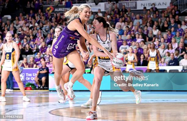 Kate Walsh of the Lightning is challenged by Gretel Bueta of the Firebirds during the round 11 Super Netball match between Queensland Firebirds and...