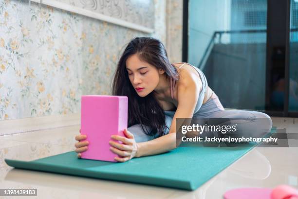 woman stretching in yoga studio - day of yoga in bangkok stock-fotos und bilder