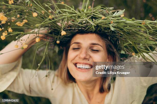 happy woman with a flower wreath on her had. - haarkranz stock-fotos und bilder