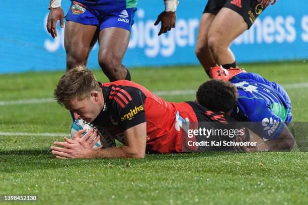 Fergus Burke of the Crusaders dives over to score a try during the round 14 Super Rugby Pacific match between the Crusaders and the Fijian Drua at...