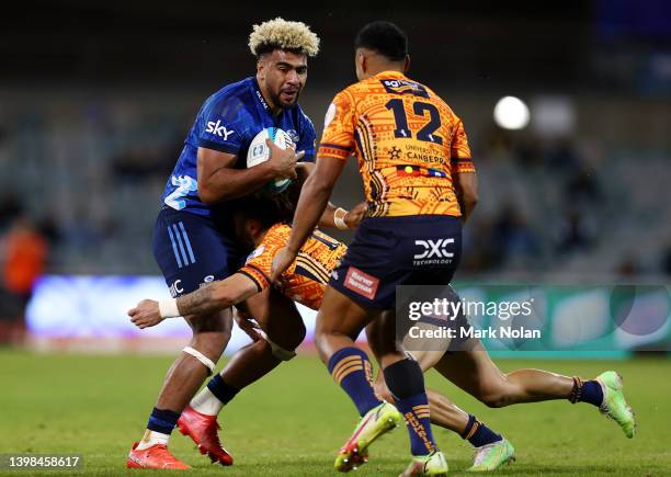 Hoskins Sotutu of the Blues is tackled during the round 14 Super Rugby Pacific match between the ACT Brumbies and the Blues at GIO Stadium on May 21,...