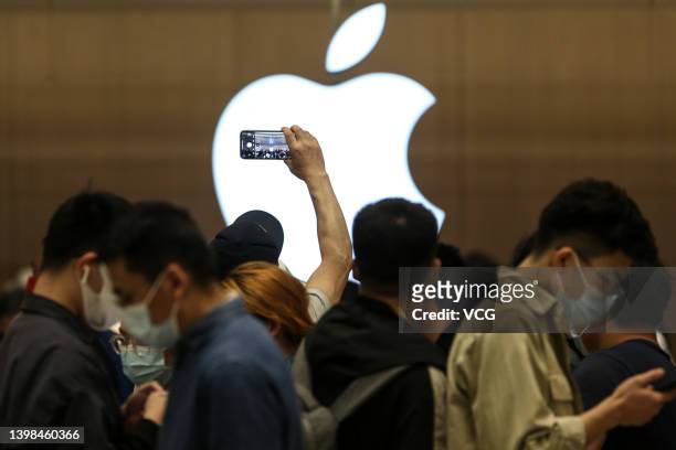 Customers line up to enter a new Apple store at Wuhan International Plaza on May 21, 2022 in Wuhan, Hubei Province of China.
