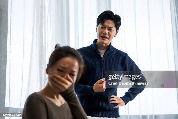an angry husband and a weeping wife - husband stock pictures, royalty-free photos & images