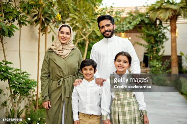 outdoor-porträt einer fröhlichen saudischen familie mit zwei kindern - portrait frau arabisch frontal stock-fotos und bilder