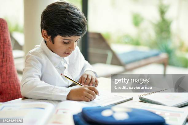 saudi schoolboy doing homework - learn arabic stock pictures, royalty-free photos & images