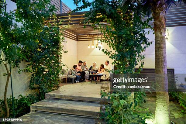 multi-generation saudi family enjoying secluded patio - saudi relaxing stock pictures, royalty-free photos & images