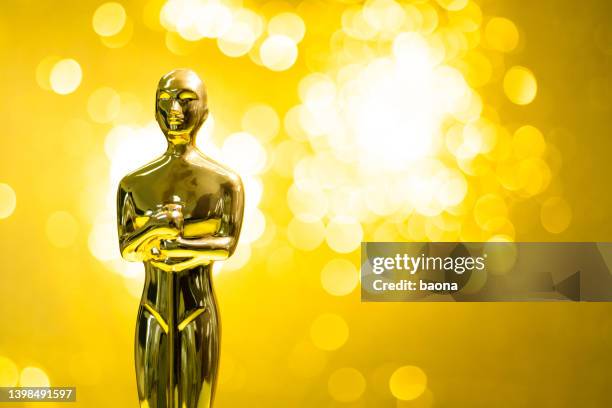 golden statuette on shiny yellow background - oscar awards bildbanksfoton och bilder