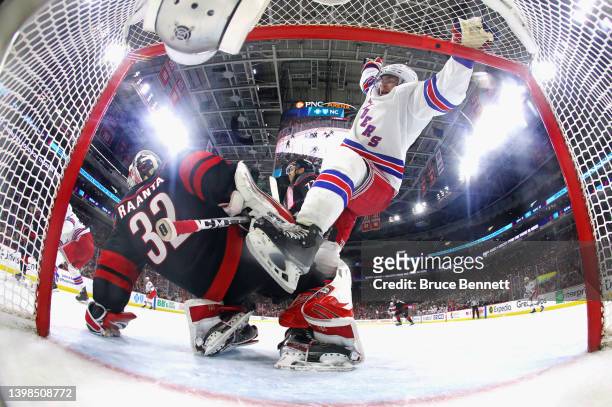 Andrew Copp of the New York Rangers gets tangled up with Antti Raanta of the Carolina Hurricanes in Game Two of the Second Round of the 2022 Stanley...