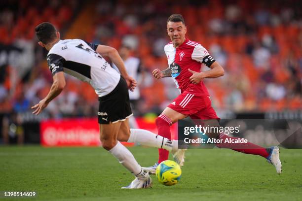 Iago Aspas of Celta Vigo is challenged by Gabriel Paulista of Valencia during the LaLiga Santander match between Valencia CF and RC Celta de Vigo at...