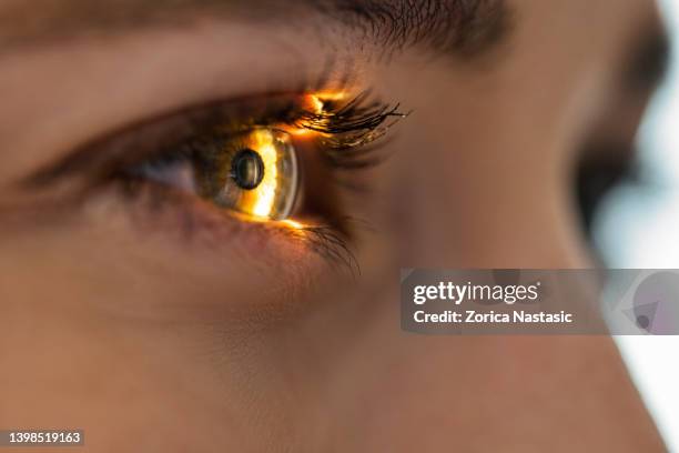 lichtstrahl scheint durch netzhaut und linse bei der sehprüfung - medical study stock-fotos und bilder