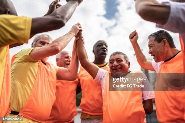 senior men celebrating on the soccer field - including a disabled person - disabilitycollection stock pictures, royalty-free photos & images
