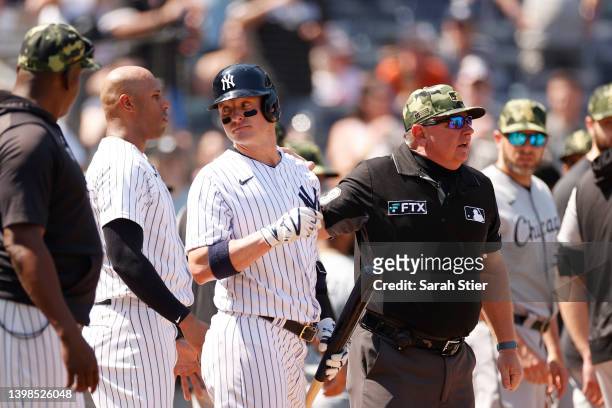 Josh Donaldson of the New York Yankees talks with Aaron Hicks and umpire Will Little after a benches-clearing dispute with Yasmani Grandal of the...