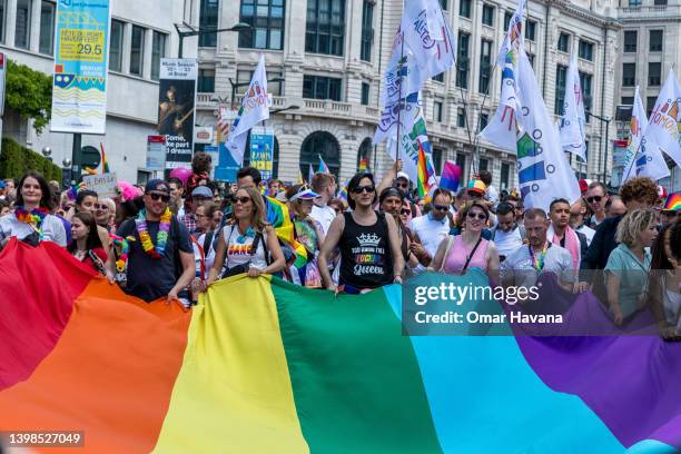 Participants in the annual Pride Parade hold a giant rainbow flag as they march through the streets of the Belgian capital on May 21, 2022 in...
