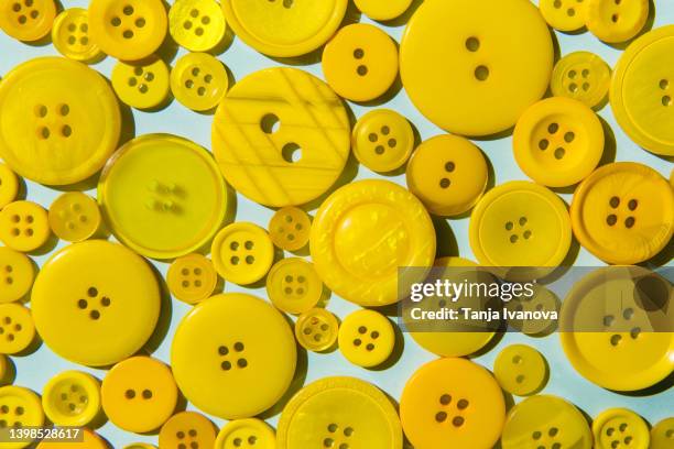 yellow buttons on blue background - button sewing item stock pictures, royalty-free photos & images