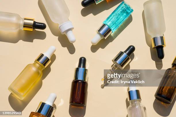 set of different luxury beauty cosmetics products with transparent liquid on pastel beige background. - face oil stock pictures, royalty-free photos & images