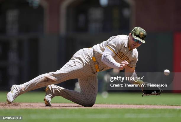 Luke Voit of the San Diego Padres dives for a ball that gets past him for a double off the bat of Mike Yastrzemski of the San Francisco Giants in the...