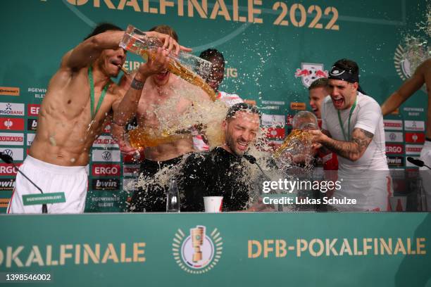 Domenico Tedesco, Head Coach of RB Leipzig is showered in beer by Yussuf Poulsen and teammates in the post match press conference after their sides...