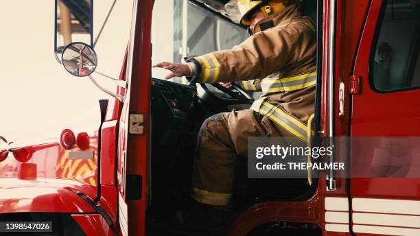 un pompier sur le point de fermer la porte de son camion - pompier photos et images de collection