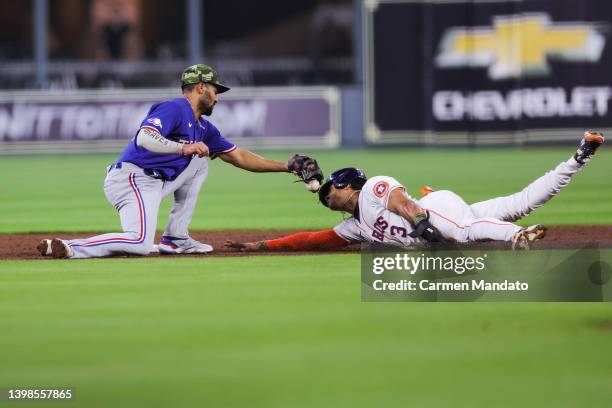 Jeremy Pena of the Houston Astros steals second base ahead of Marcus Semien of the Texas Rangers during the second inning at Minute Maid Park on May...