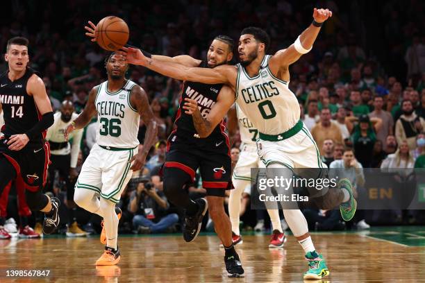 Jayson Tatum of the Boston Celtics and Caleb Martin of the Miami Heat compete for the ball in the third quarter in Game Three of the 2022 NBA...