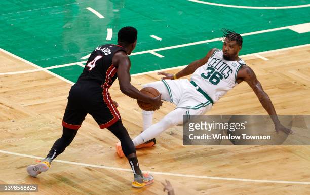 Marcus Smart of the Boston Celtics falls while defending Victor Oladipo of the Miami Heat in the third quarter in Game Three of the 2022 NBA Playoffs...