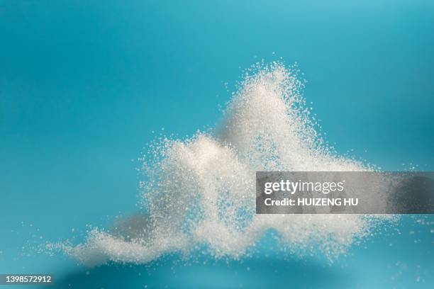 flying sugar on blue background - zucker stock-fotos und bilder