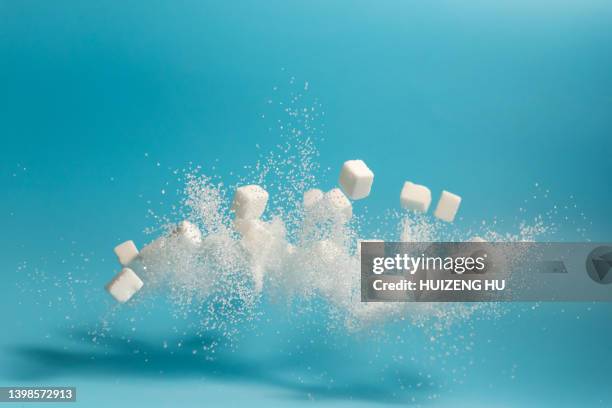 white sugar and cubes flying - sugar stockfoto's en -beelden