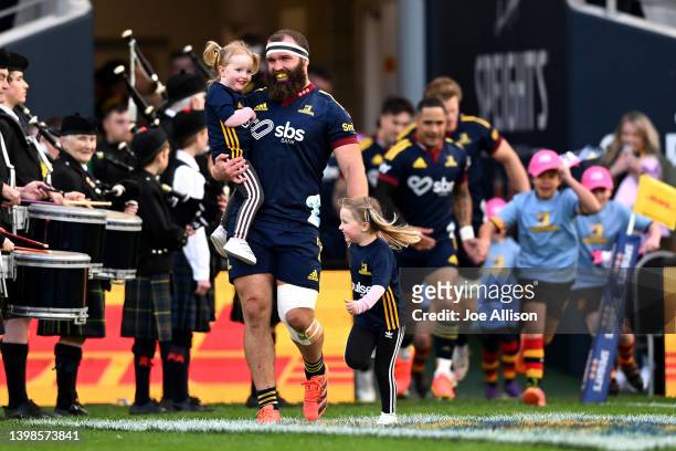 Liam Coltman of the Highlanders runs out onto the field with his daughters during the round 14 Super Rugby Pacific match between the Highlanders and...